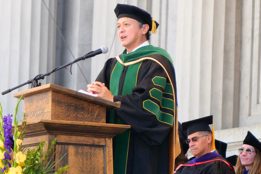 Dean Michael Lu speaking at a podium.