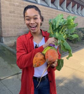 Whitney Francis smiling while holding vegetables