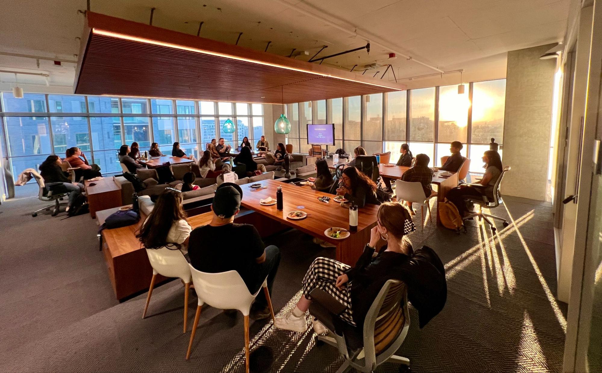 People seated around a large table in a modern-looking conference room.