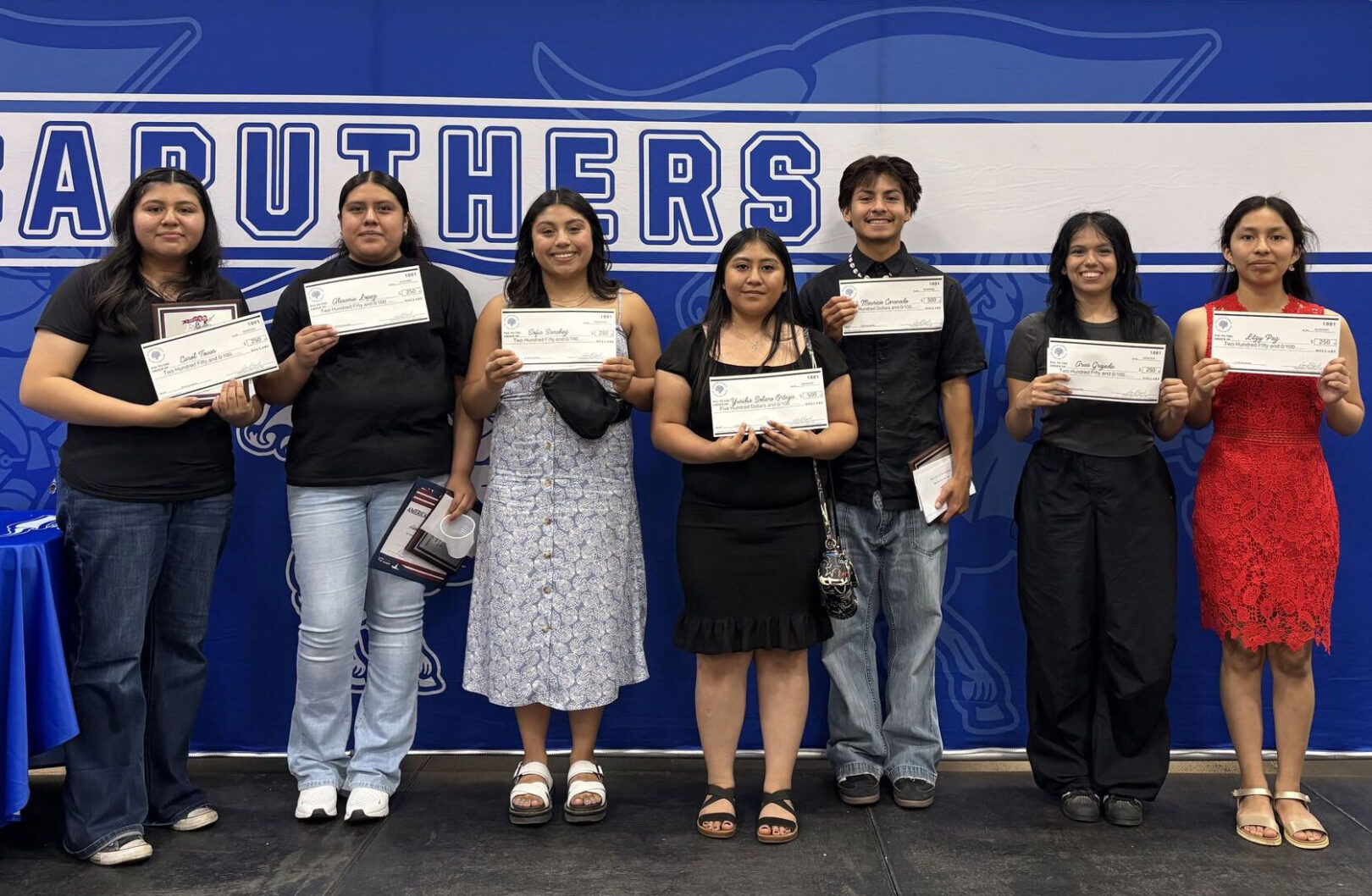 Participants lined up whil proudly holding certificates in front of them.