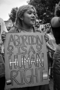 A person holding a sign reading "Abortion is a human right".