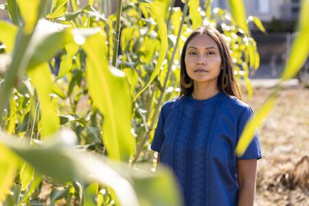 Marlena Robbins, an PhD student at the UC Berkeley School of Public Health, stands for a portrait next to rows of corn at the Berkeley Student Farm in Berkeley, Calif. on Thursday, Aug. 18, 2022.